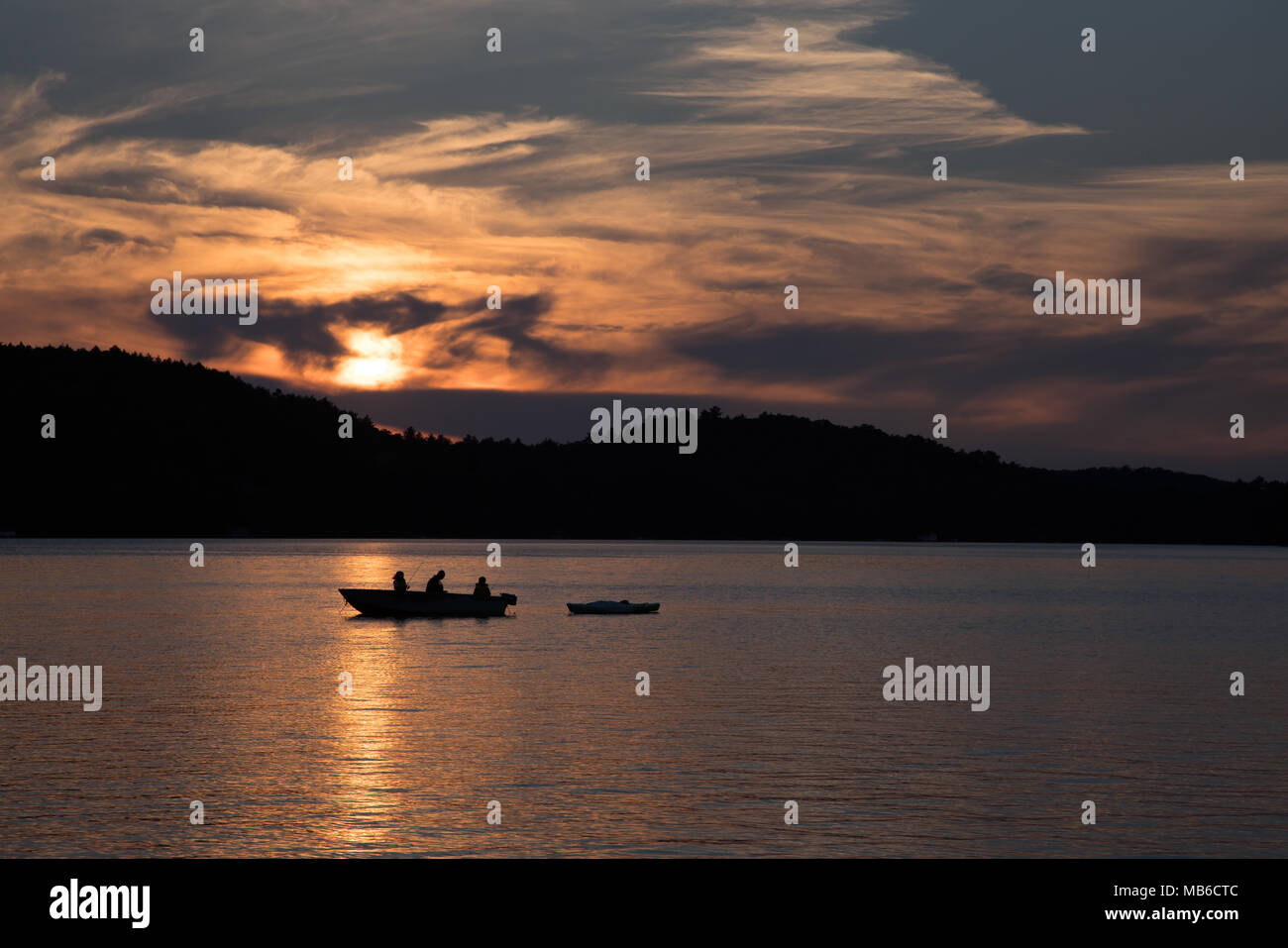 Family fishing adventure on boat and kayak in Ontario lake at sunset Stock Photo