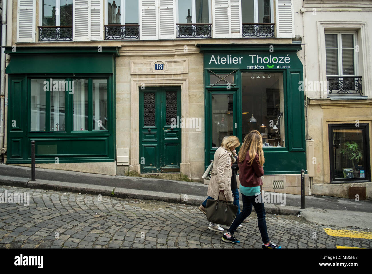 Two friends walk past a typically chic Parisian Store. Stock Photo
