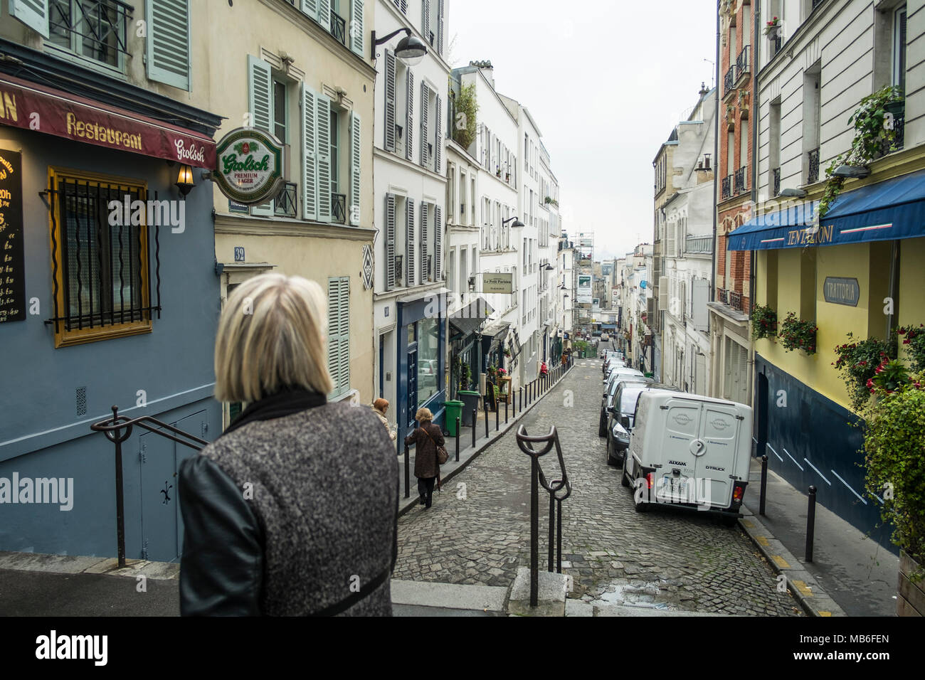 A lady looks back at the fabulous Rue Tholoze as she walks uphill. Stock Photo