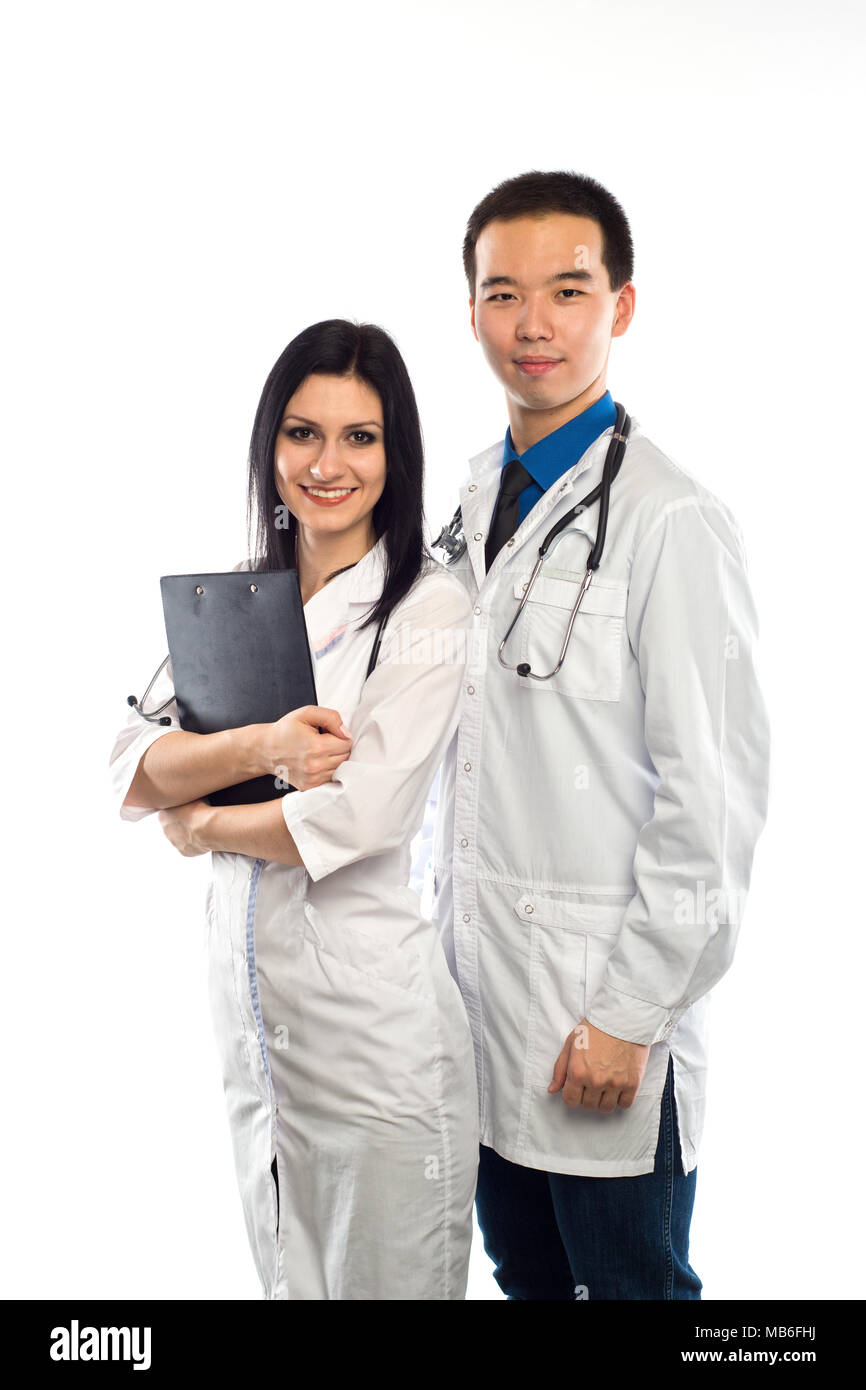 Asian doctor with a smiling happy Caucasian nurse or medical colleague standing back to back with folded arms isolated on white, upper body portrait c Stock Photo