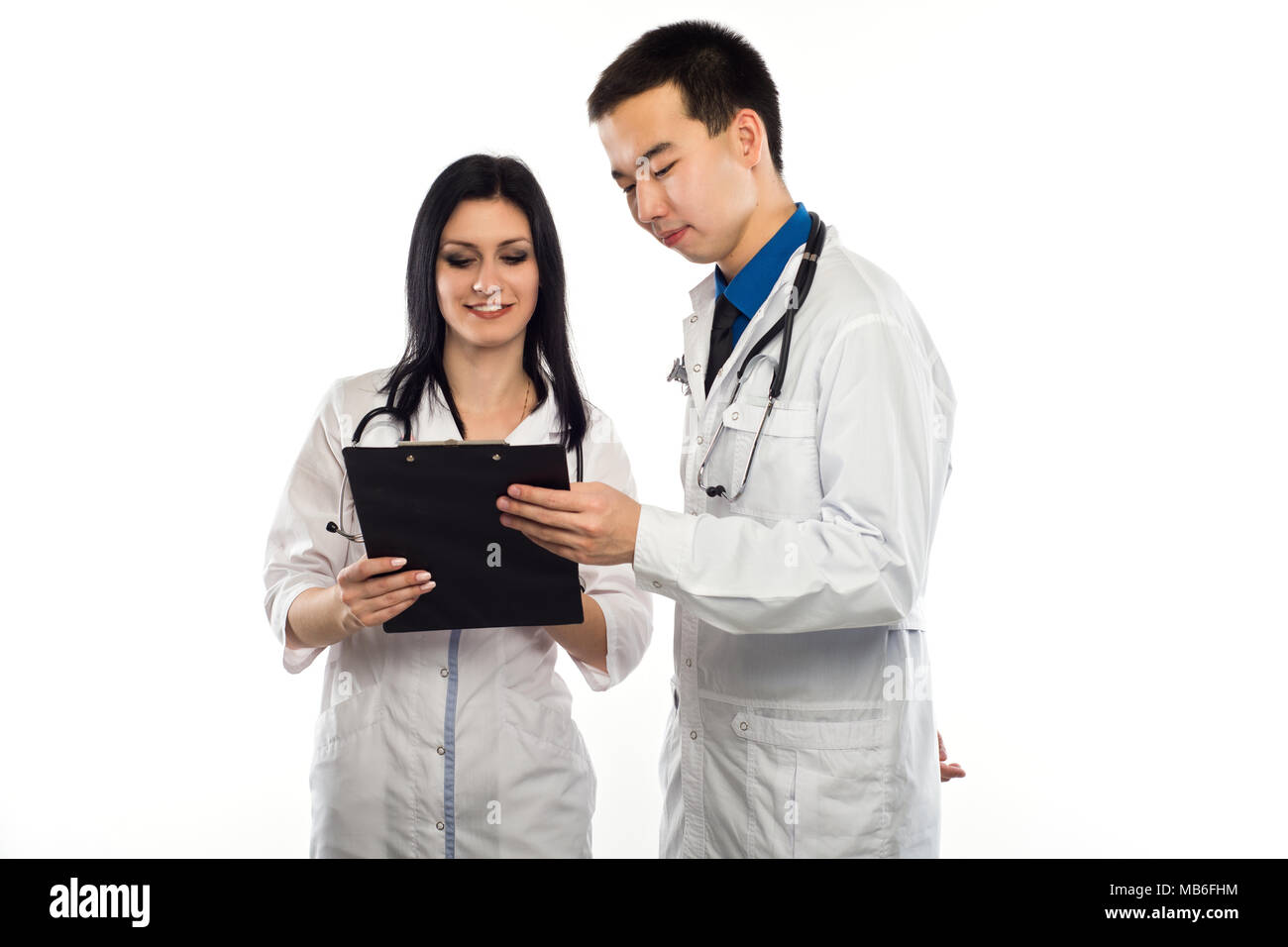 Medical multiethnic staff having discussion in a hospital hallway. Male and female nurse wearing blue scrubs working in a medical clinic. Two hospital Stock Photo