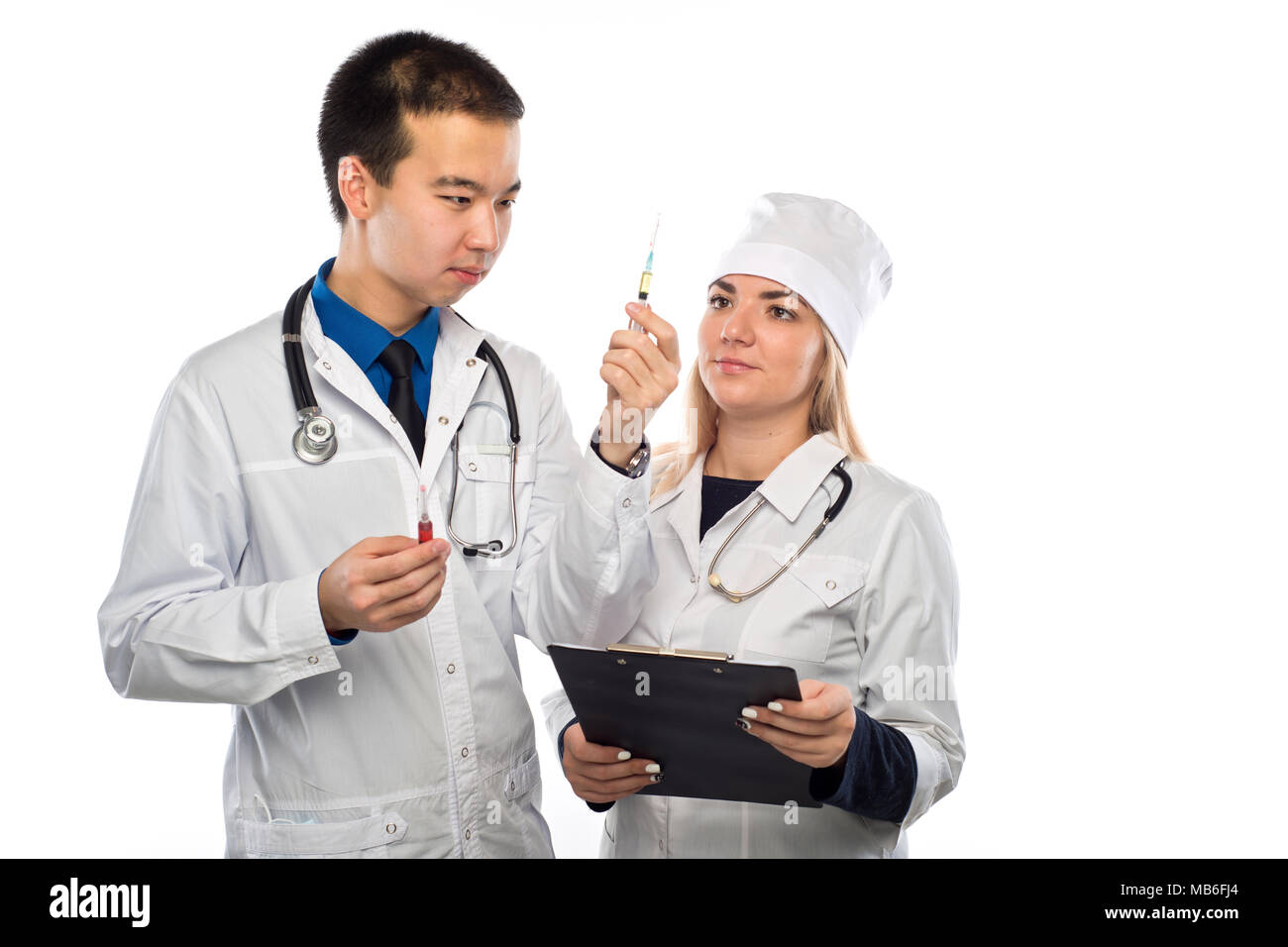 a young doctor of Asian appearance, shows a syringe with red liquid, a young girl doctor Stock Photo