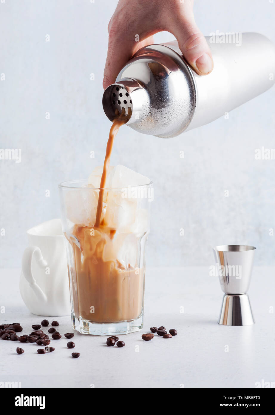pour from a shaker Coffee frappe in a tall glass with ice Stock Photo -  Alamy