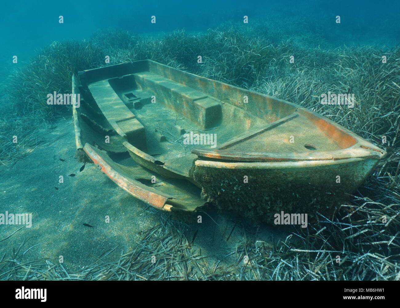 A small boat wreck underwater on a seabed with Neptune grass, Mediterranean sea, Catalonia, Costa Brava, Spain Stock Photo