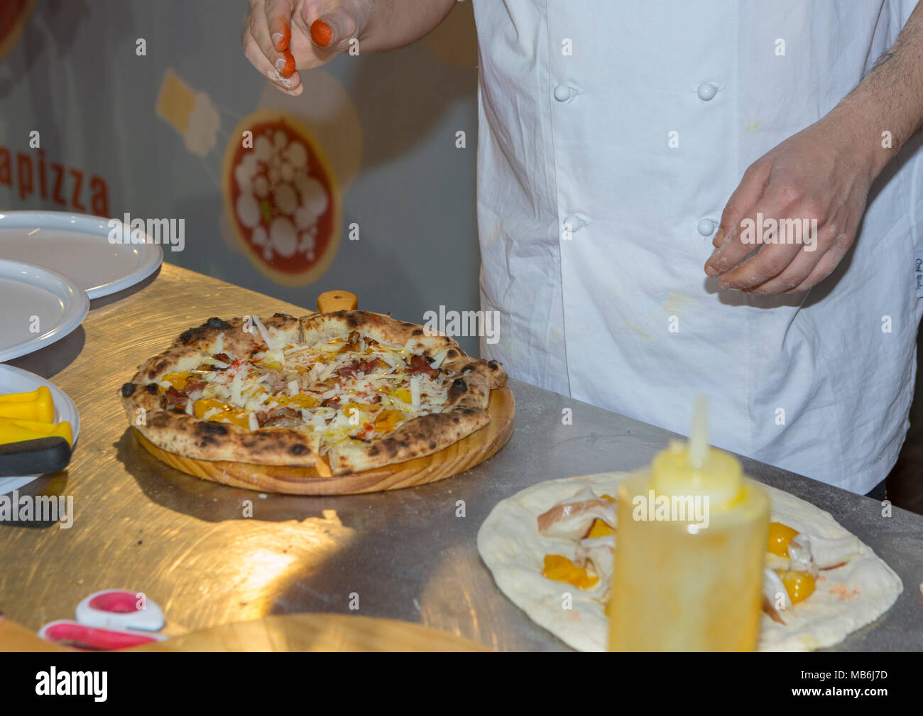 A pizza chef demonstrates the finer skills of pizza preparation Stock