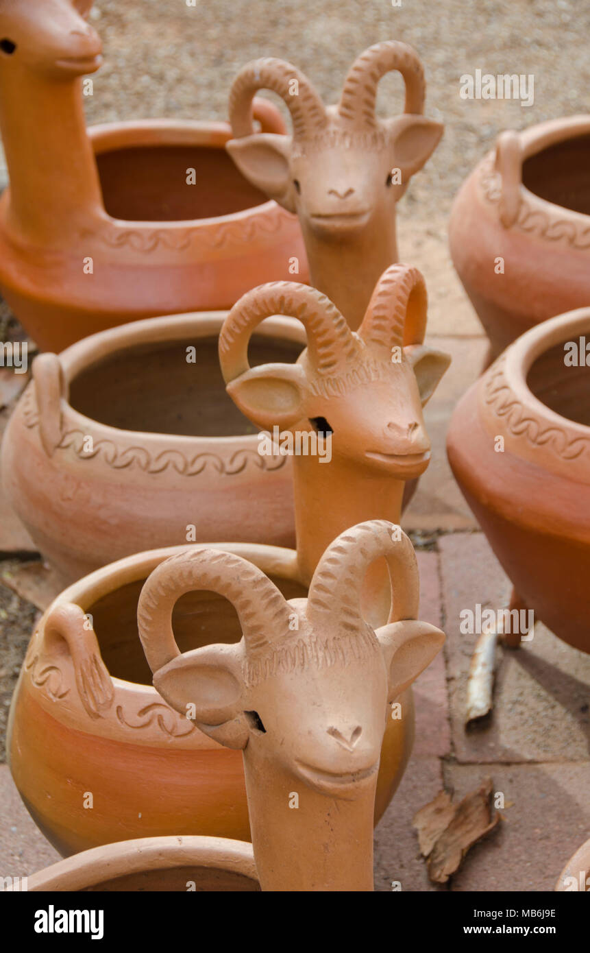 Several empty flower pot containers created in the shape of rams or sheep with horns are displayed together. Stock Photo