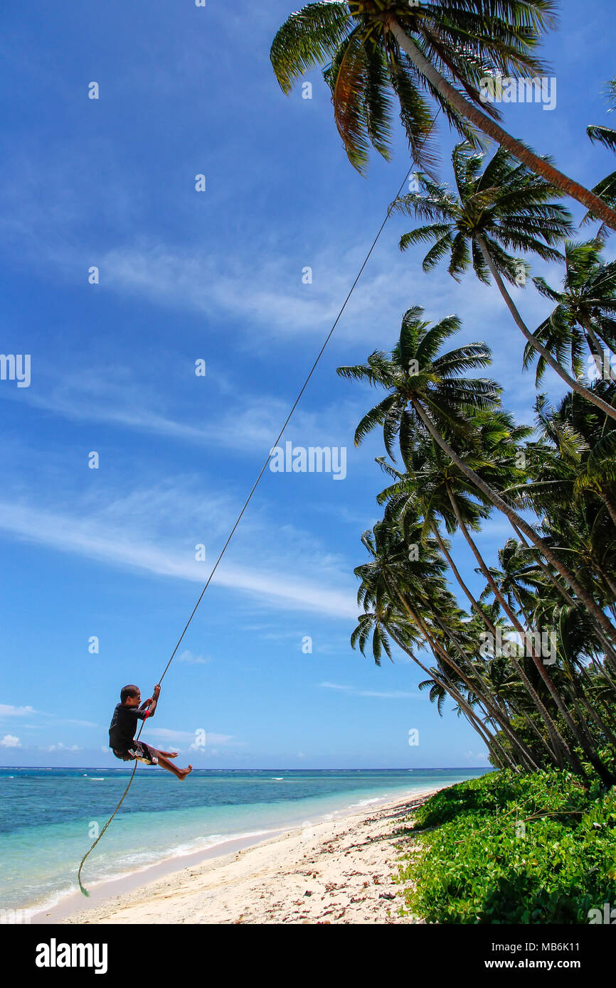 local-boy-swinging-on-a-rope-swing-in-lavena-village-taveuni-island