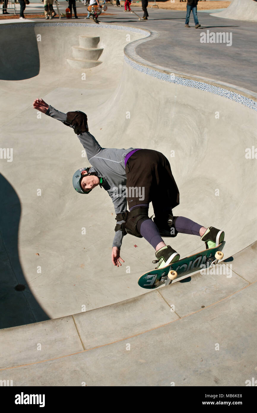 A heavily padded veteran skateboarder rides the big bowl during 'Old Man Sundays,' at the skateboard park in Kennesaw, GA on November 24, 2013. Stock Photo