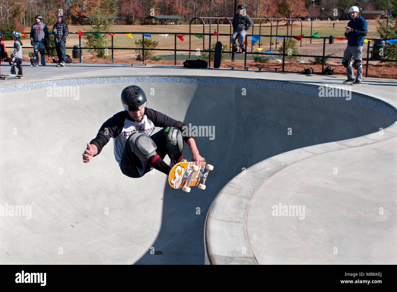 A veteran skateboarder goes airborne while grabbing his board during 'Old Man Sundays,' at the skateboard park in Kennesaw, GA on November 24, 2013. Stock Photo