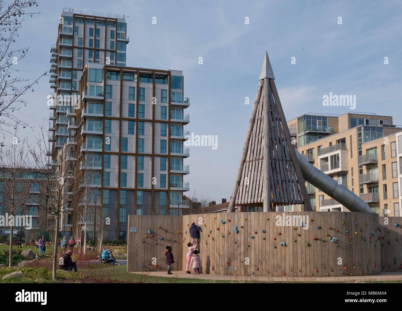 Children and parents in playground by new luxury housing buildings next ...