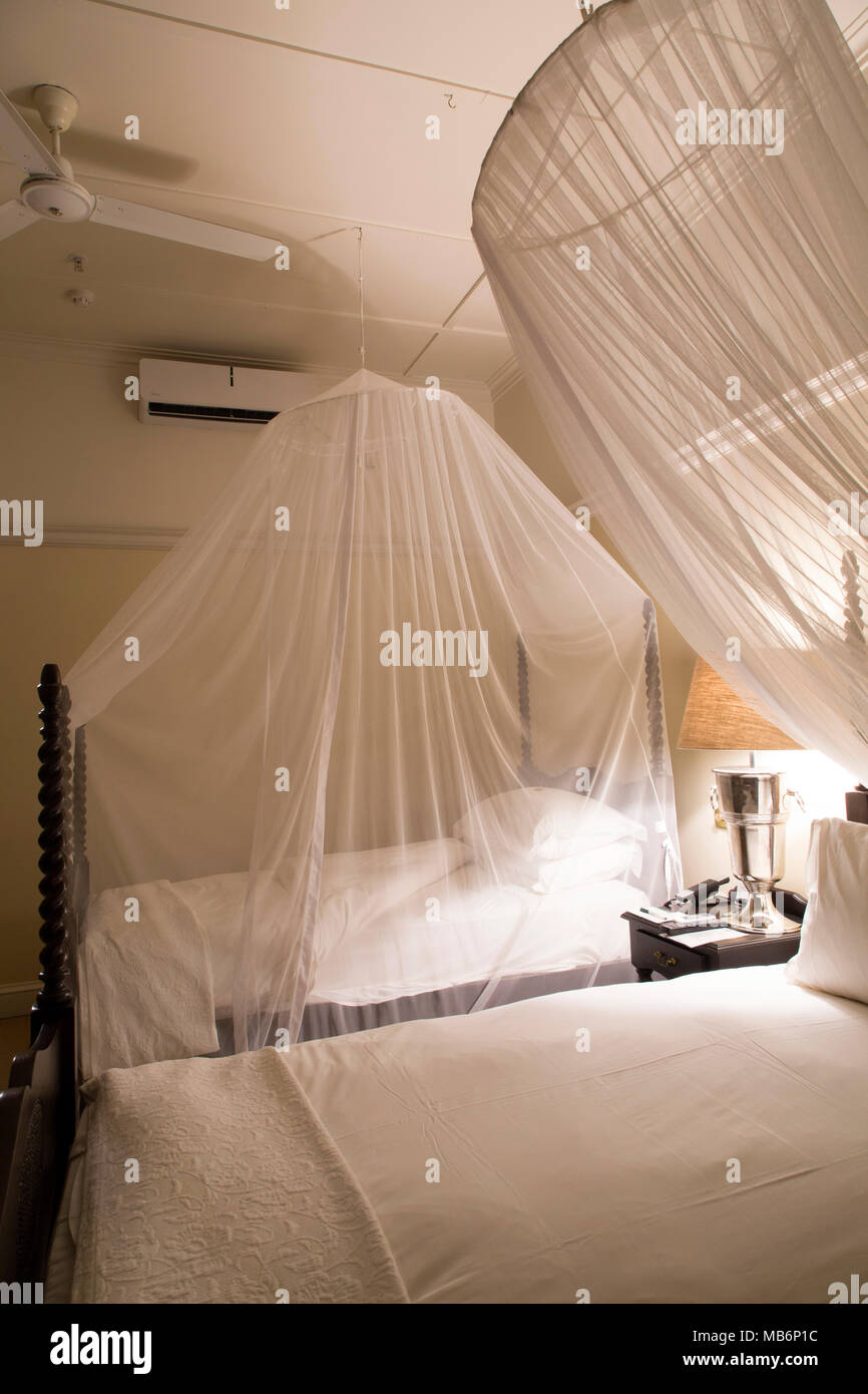 Mosquito nets in use in a bedroom at the Victoria Falls Hotel at Victoria Falls, Zimbabwe. Using a net helps reduce the risk of malaria. Stock Photo
