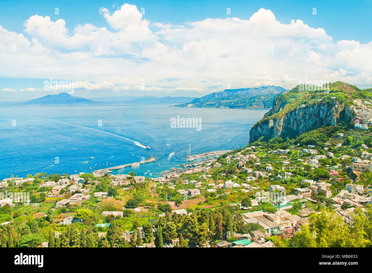 beautiful aerial view of Marina Grande port, boats and houses on island of Capri with Mount Vesuvius at background on sunny summer day Stock Photo