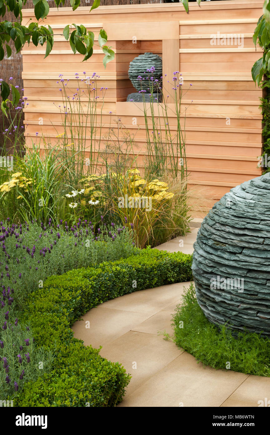 Original spherical stone centrepiece sculptures, path & medicinal plants - 'Embracing Tranquility' garden, RHS Flower Show, Tatton Park,  England, UK. Stock Photo