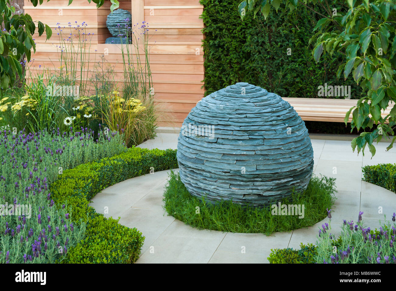 Original spherical stone centrepiece sculpture, path & medicinal plants - 'Embracing Tranquility' garden, RHS Flower Show, Tatton Park,  England, UK. Stock Photo