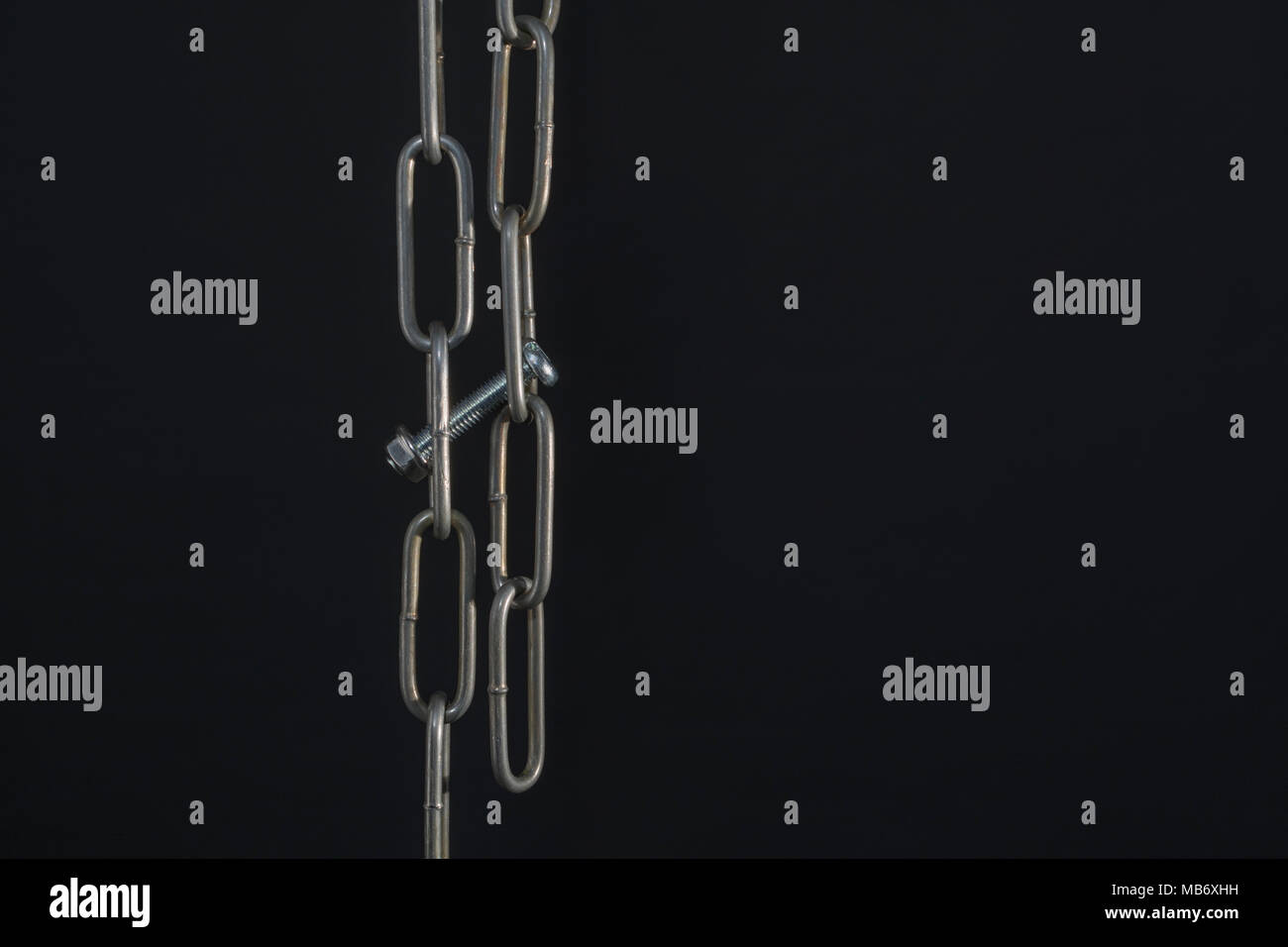 Metal chains threaded with nut and bolt - as metaphor for cryptocurrency blockchain concept. Stock Photo