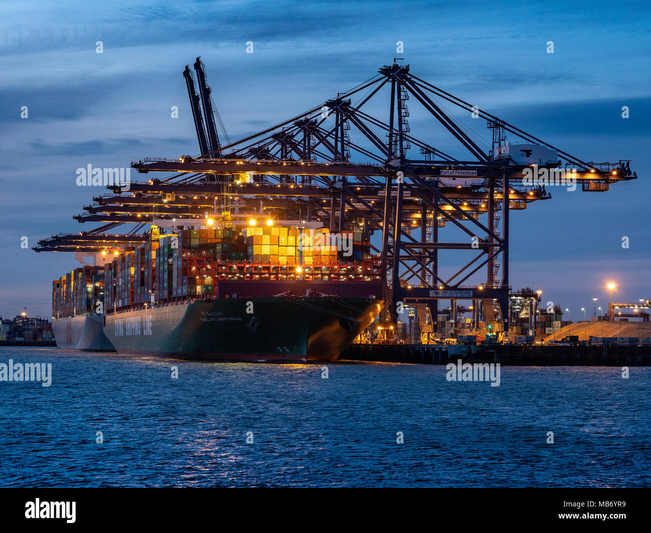 World Trade - Large Container Ships loading and unloading containers at the Port of Felixstowe, the UK's largest container port at dusk. Stock Photo