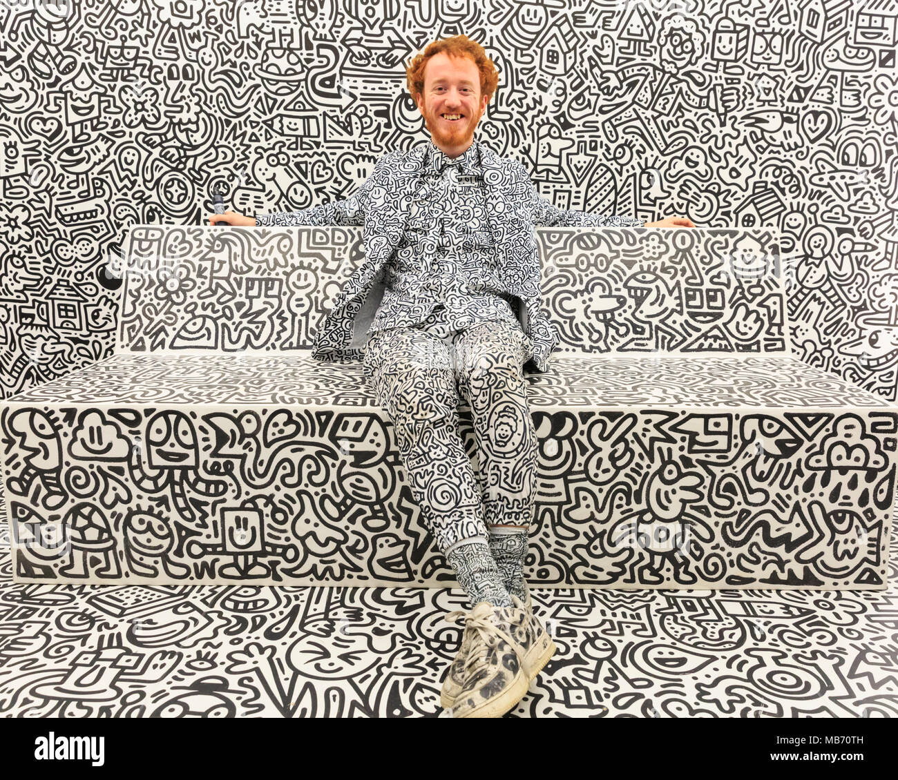 Exchange Square, London, 7th April 2018. Artist Sam Cox, portrait, known as 'Mr. Doodle', smiling. Mr Doodle, poses with his doodles artwork in 'The Doodle Room'. Visitors and art lovers have fun exploring the 'Sense Of Space' art exhibition and installations in Exchange Square, Broadgate, London, England, running until 18th May. Sense Of Space has four rooms overall, designed to activate the different senses. Credit: Imageplotter Stock Photo