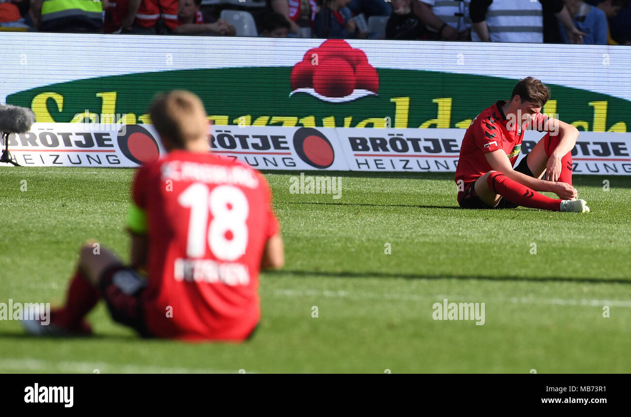 Freiburg, Germany. 7th April 2018. Soccer: Bundesliga, SC Freiburg vs VfL  Wolfsburg, in the Schwarzwald Stadium. Freiburg's Nils Petersen (L) and  Janik Haberer (R) sitting on the pitch after a 2:0 defeat.