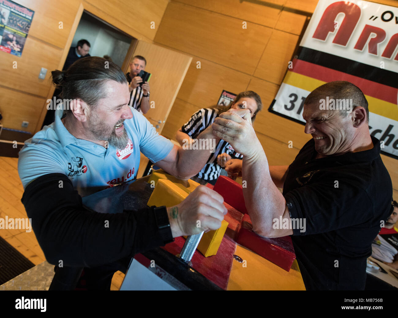 07 April 2018, Germany, Rodenbach: Andreas Berend from Eisleben (L) and Stefan Metka from Hanau standing across from each other whilst armwrestling. Around 100 athletes are taking part in the 31st championship. Photo: Andreas Arnold/dpa Stock Photo