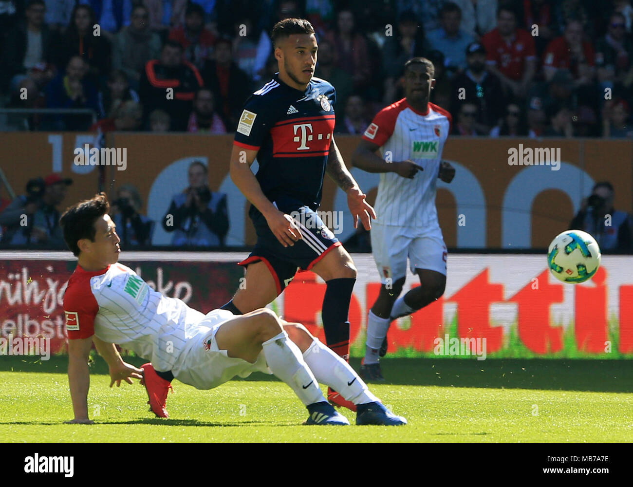 Augsburg, Germany. 7th Apr, 2018. Bayern Munich's Corentin Tolisso (Top) vies with Augsburg's Koo Ja-cheol during a German Bundesliga match between FC Augsburg and Bayern Munich, in Augsburg, Germany, on April 7, 2018. Bayern Munich won 4-1 to clinch its sixth consecutive Bundeslisga title ahead of schedule at the 29th round on Saturday. Credit: Philippe Ruiz/Xinhua/Alamy Live News Stock Photo