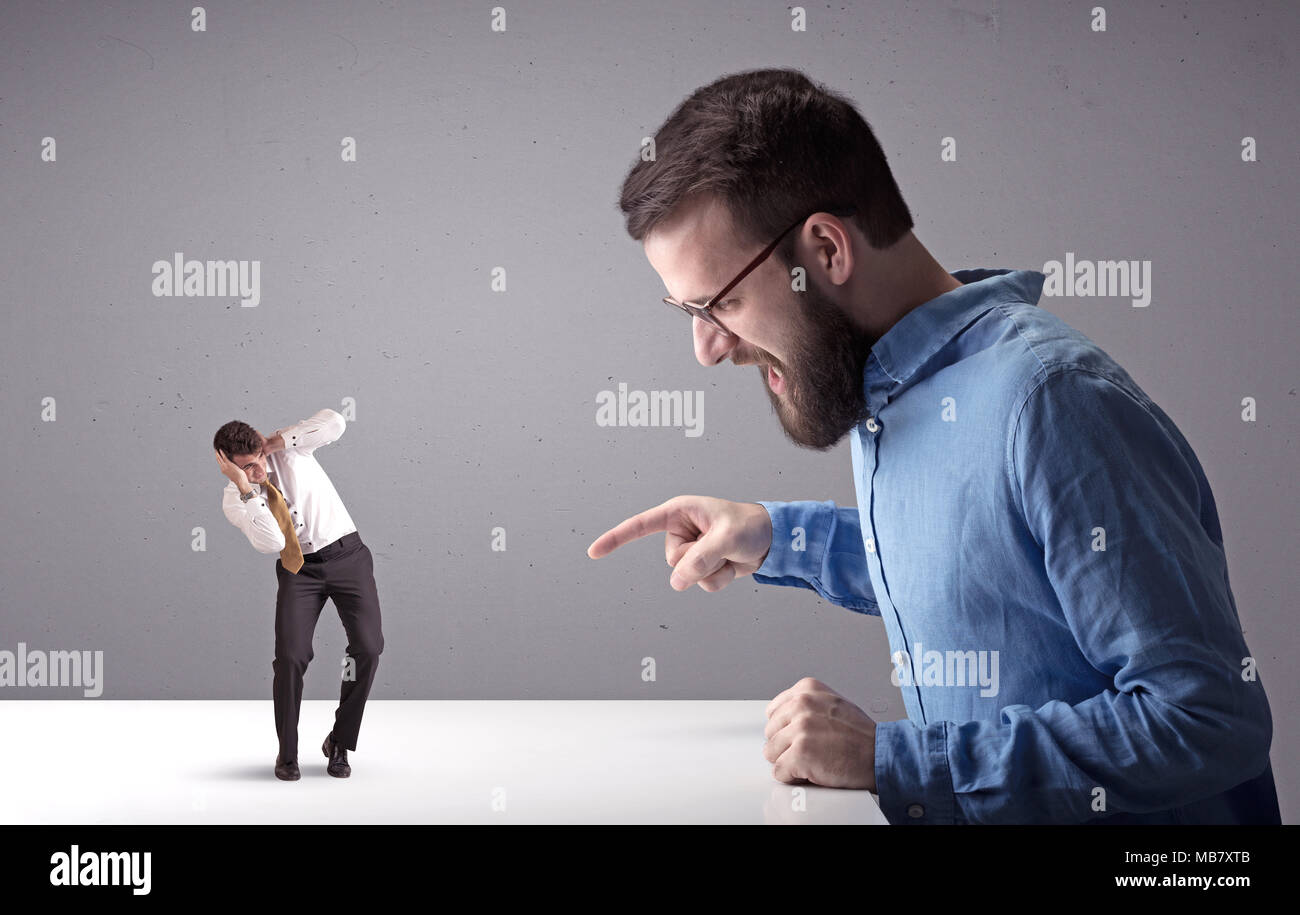 Young professional businessman being angry with an other miniature ...