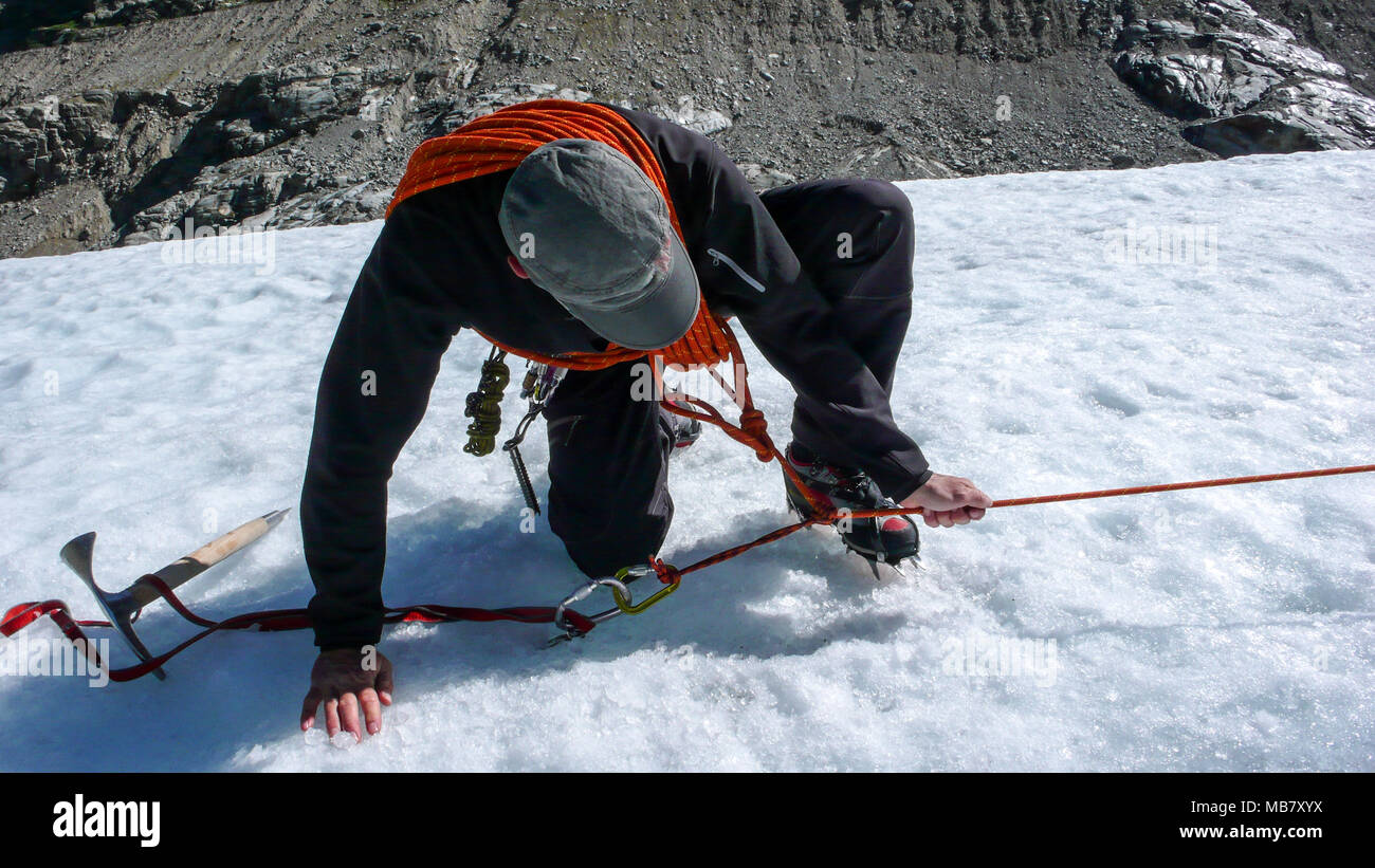 one male mountain guide installing a pulley system for crevasse rescue