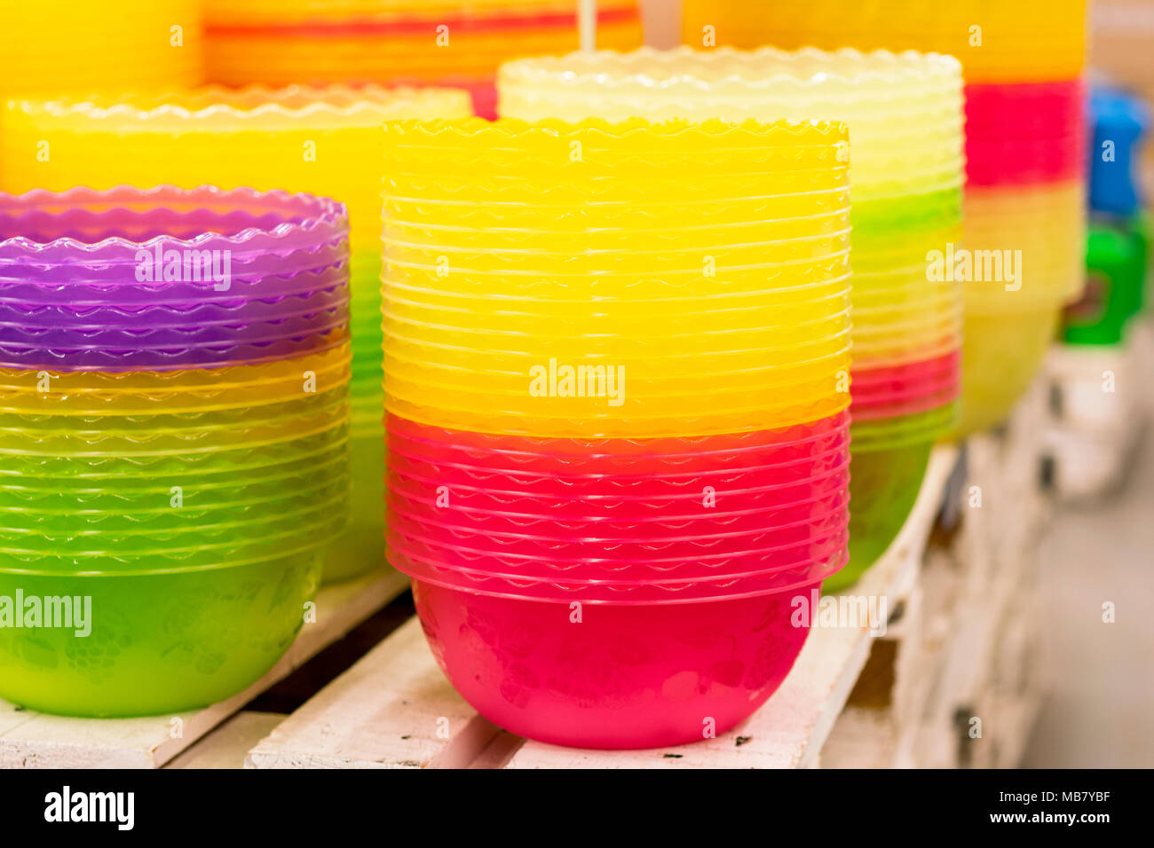 Plastic multi-colored bowls on the shelf in the store. Stock Photo