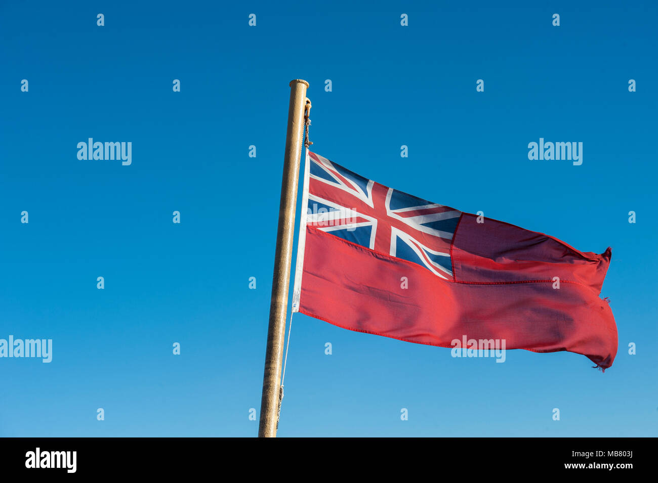 A Royal Ensign flag flies on the stern of a ship in Scotland Stock Photo