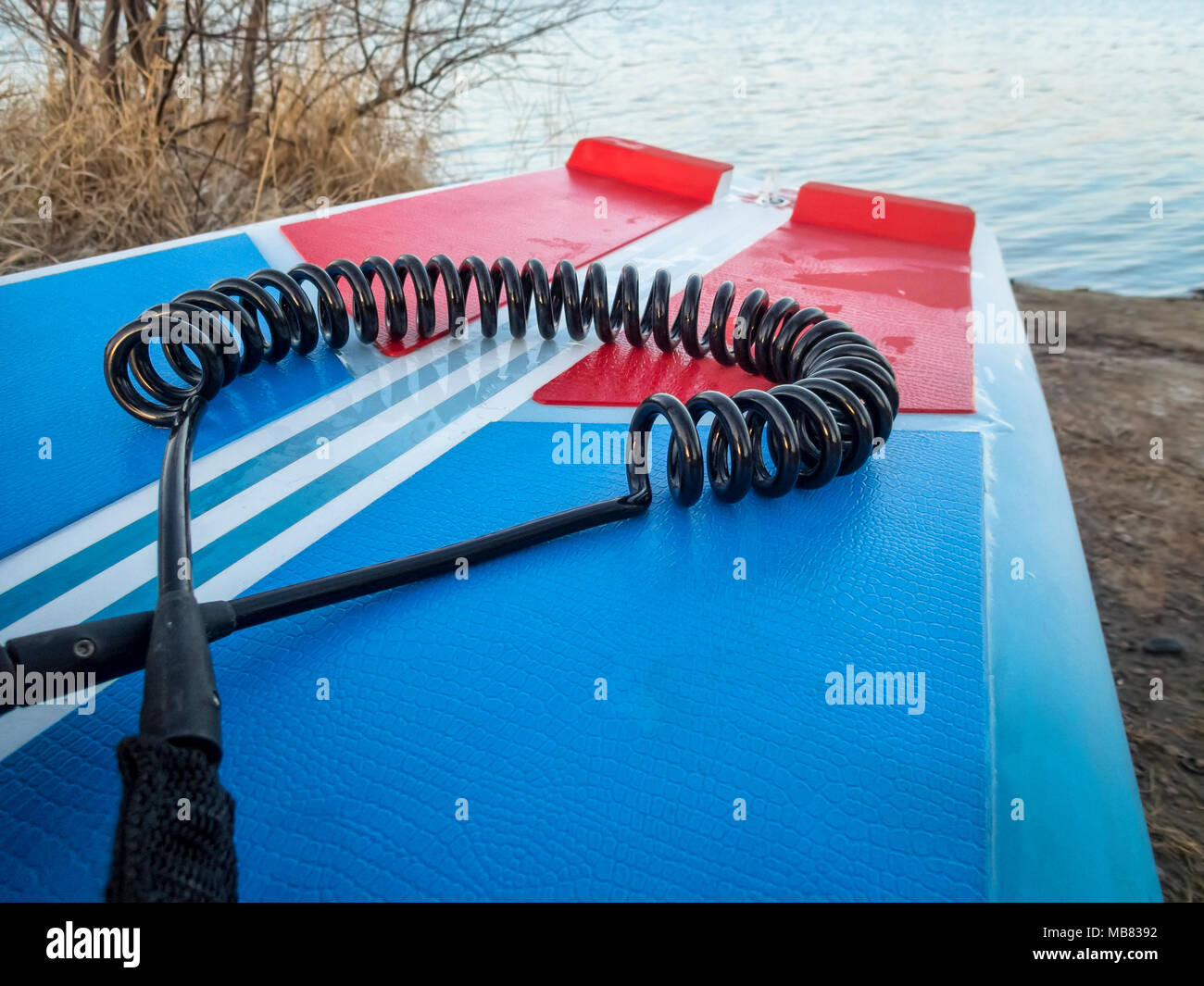 coil safety leash on a deck of stand up paddleboard safety equipment