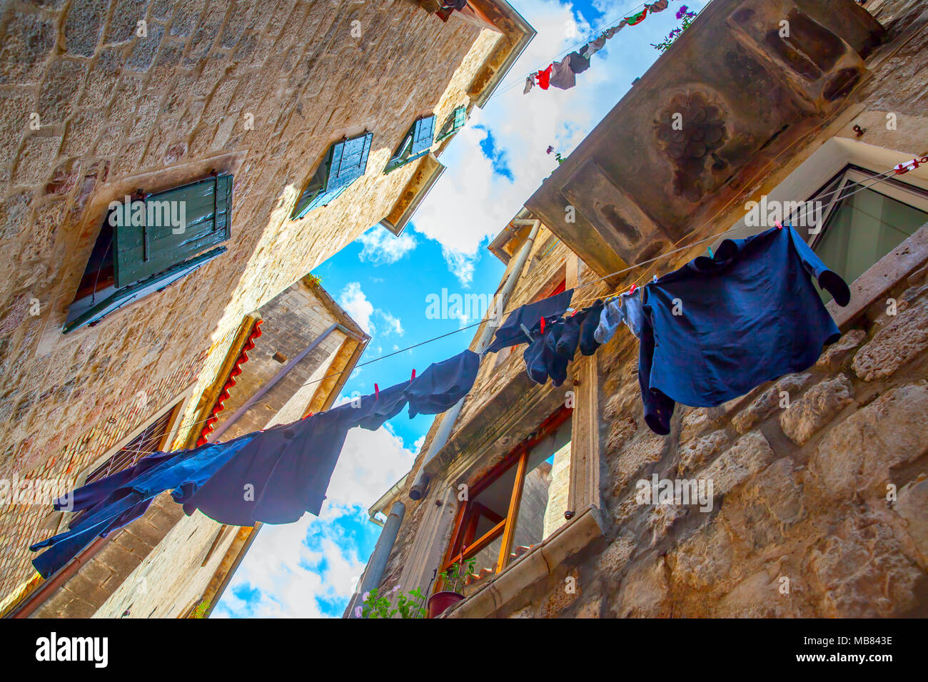 Angle view of picturesque old street in Kotor with airing clothes, Montenegro Stock Photo