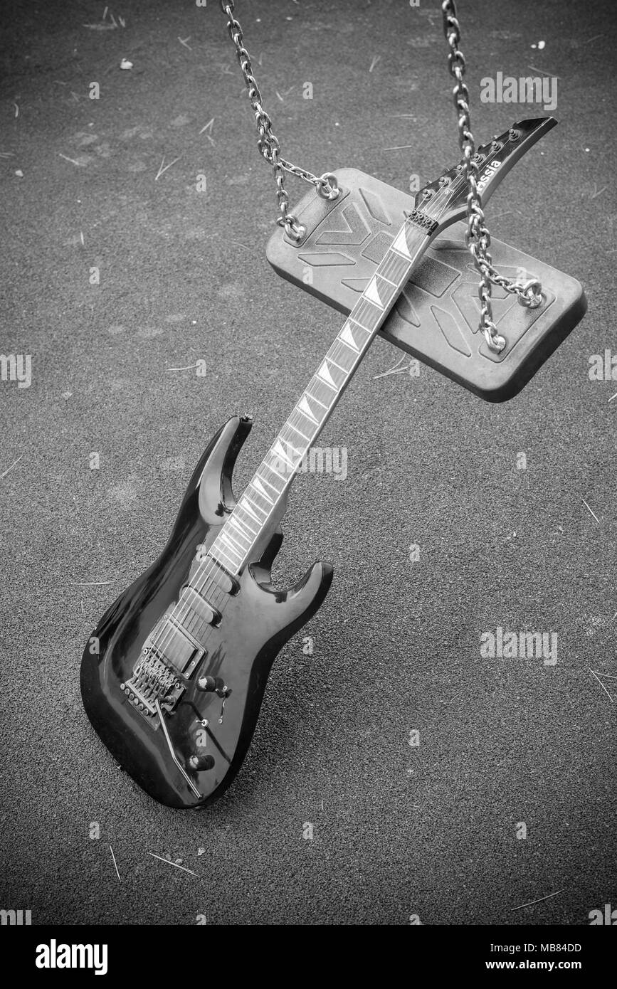 An electric guitar on a swing, a genre concept Stock Photo Alamy