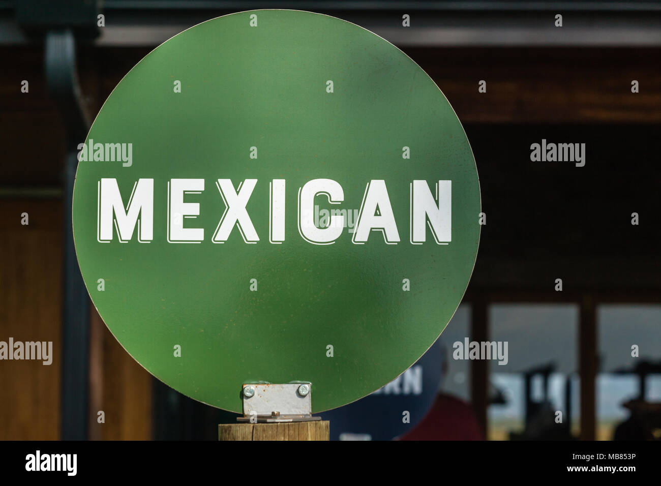 Mexican word white letters on green round disk sign board outside food store. Stock Photo