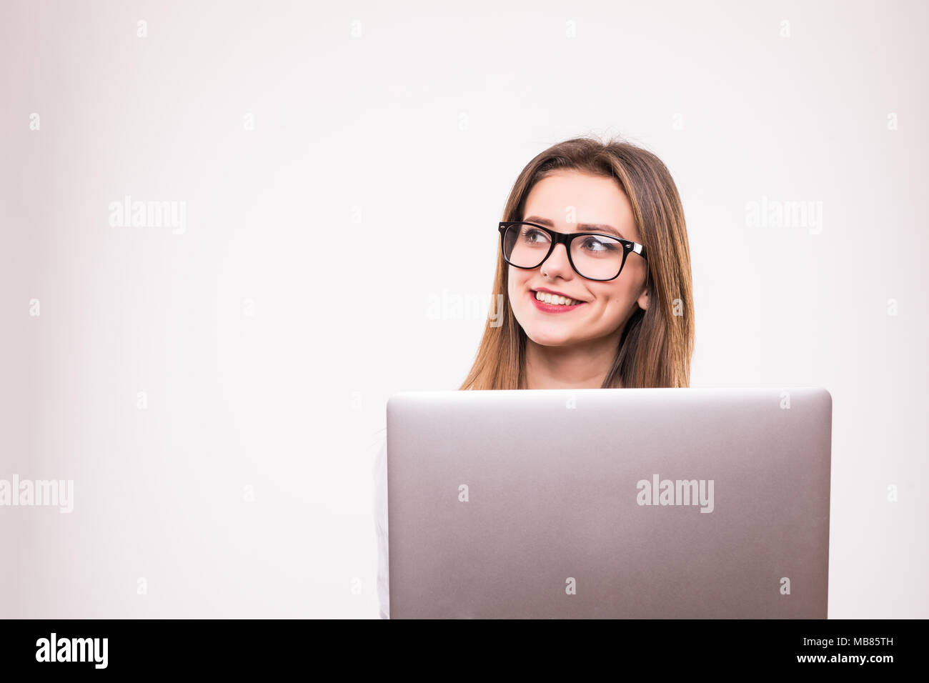 Portrait of a smiling girl holding laptop computer isolated on a white ...