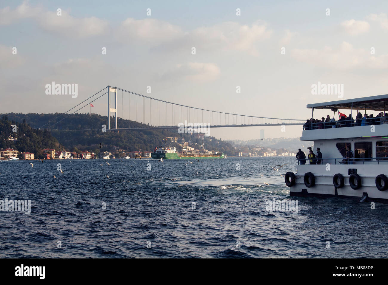 View of ferry boat, dry cargo vessel and FSM bridge in Istanbul. Stock Photo