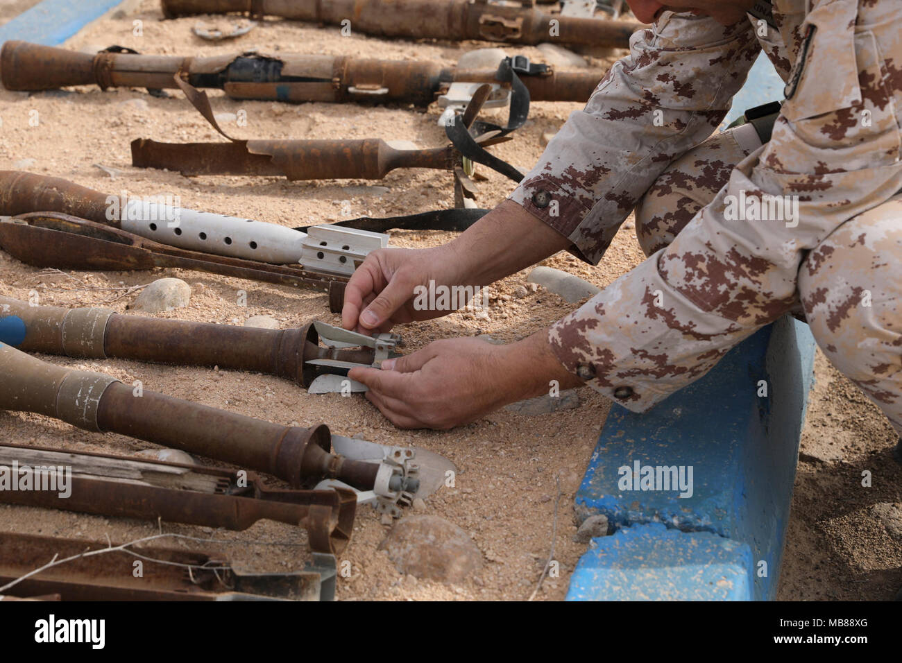 An Italian mentor checks inert rocket propelled grenade pieces as of a training area for Iraqi army students at the North Atlantic Treaty Organization (NATO) bomb disposal school, at the Besmaya