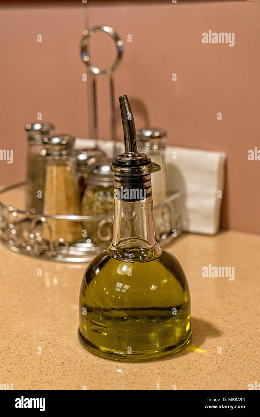 Bottle of Olive OIl and Other Condiments in the Background on a Long Island, NY, USA, Restaurant Table. Stock Photo