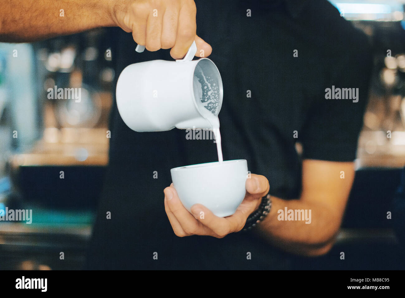 Cappuccino, mug of milk, bartender Stock Photo