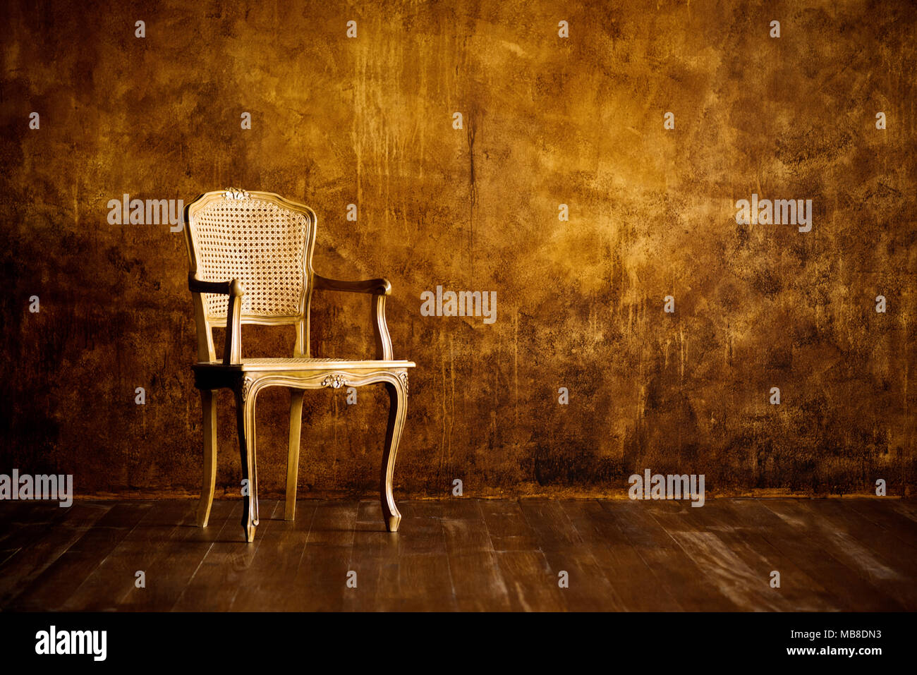 old chair on a brown wall background. Stock Photo