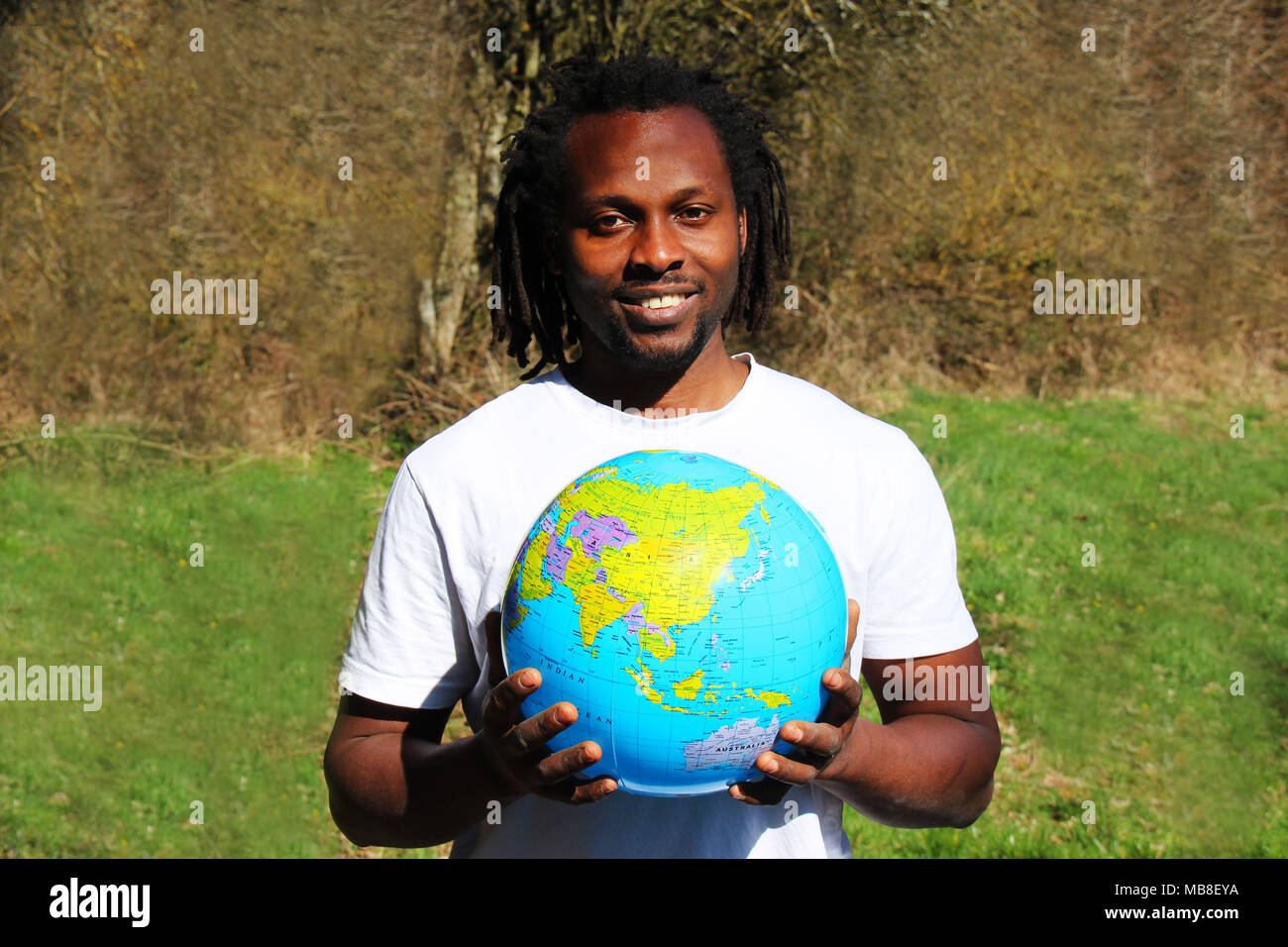 A smiling young man holds the world globe in his hands Stock Photo - Alamy