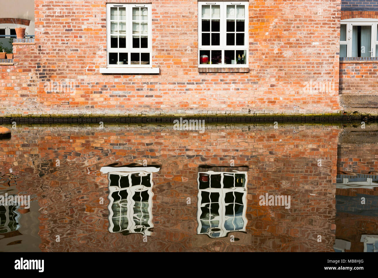 Abstract water reflections of an old red brick building in Worcester, UK Stock Photo