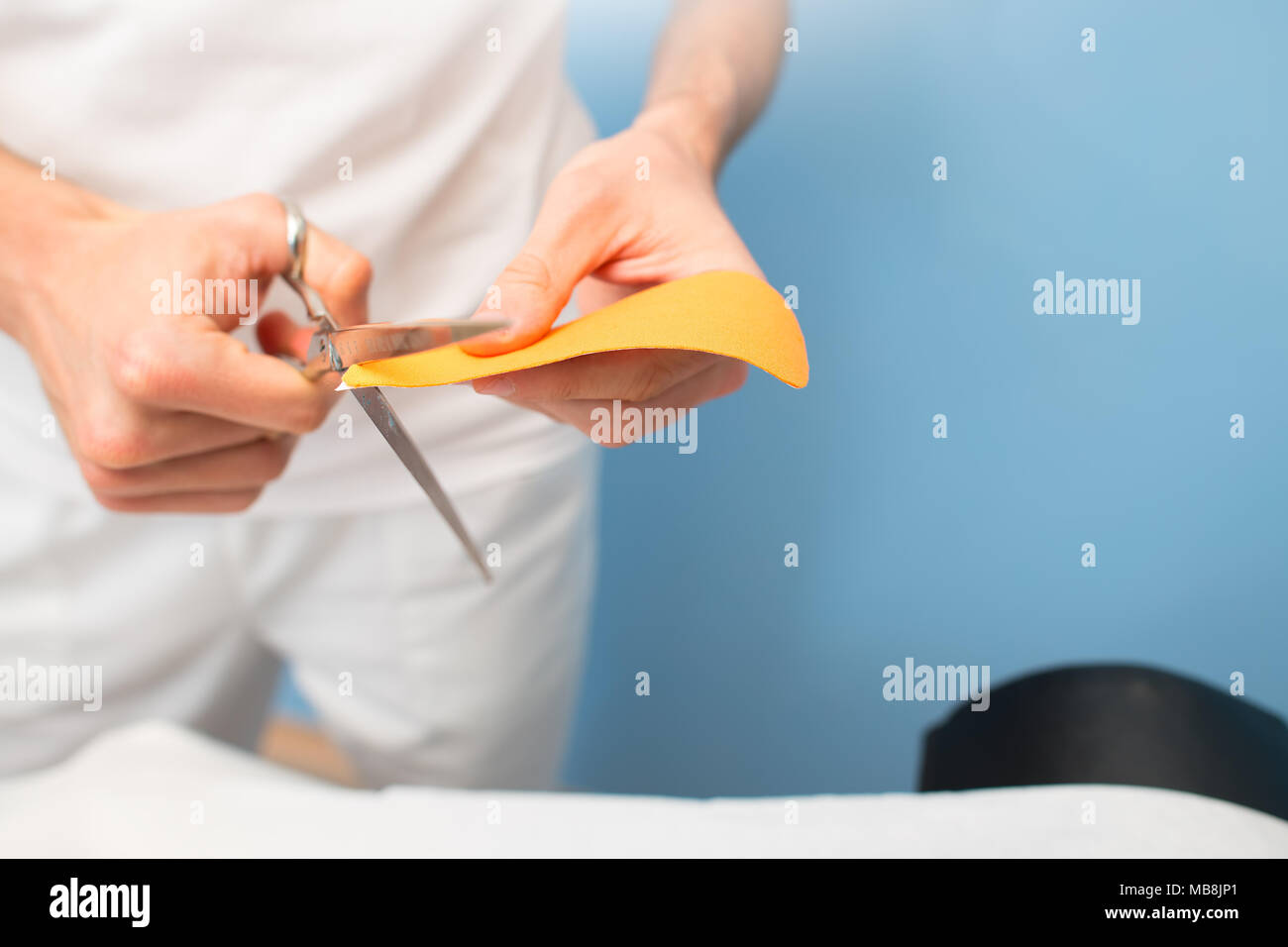 Physiotherapist prepares and cuts kinesio taping. Stock Photo