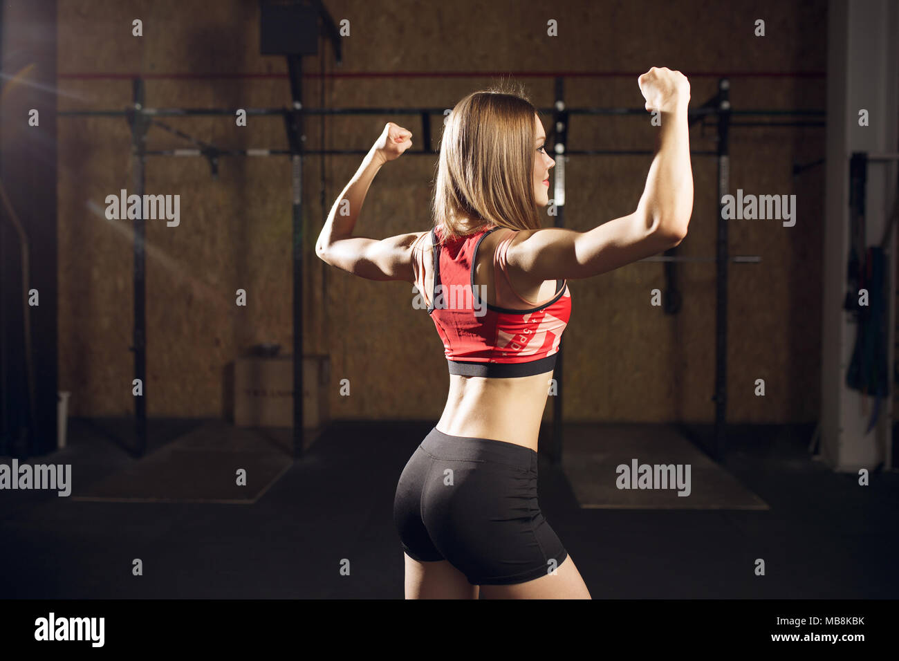 Portrait from back of sports woman showing biceps Stock Photo