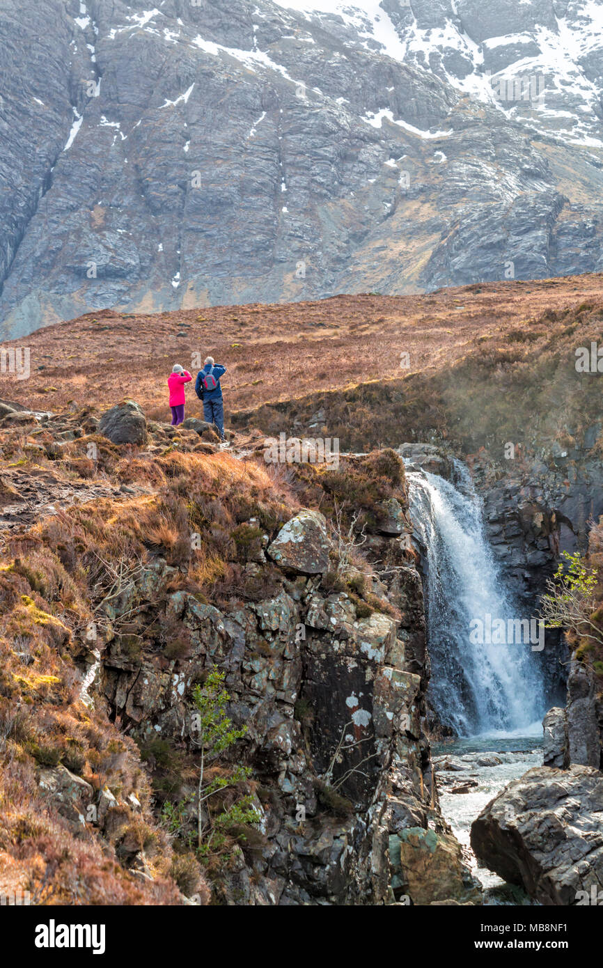 Senior couple at Black Cuillin and Fairy Pools, river Brittle, Isle of Skye, Scotland, UK in March - waterfall Stock Photo