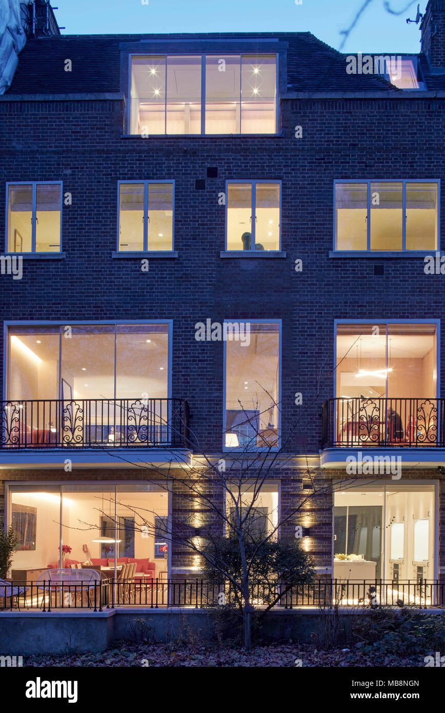 Dusk view from rear communal garden. Private residence, London, United Kingdom. Architect: PTP , 2017. Stock Photo