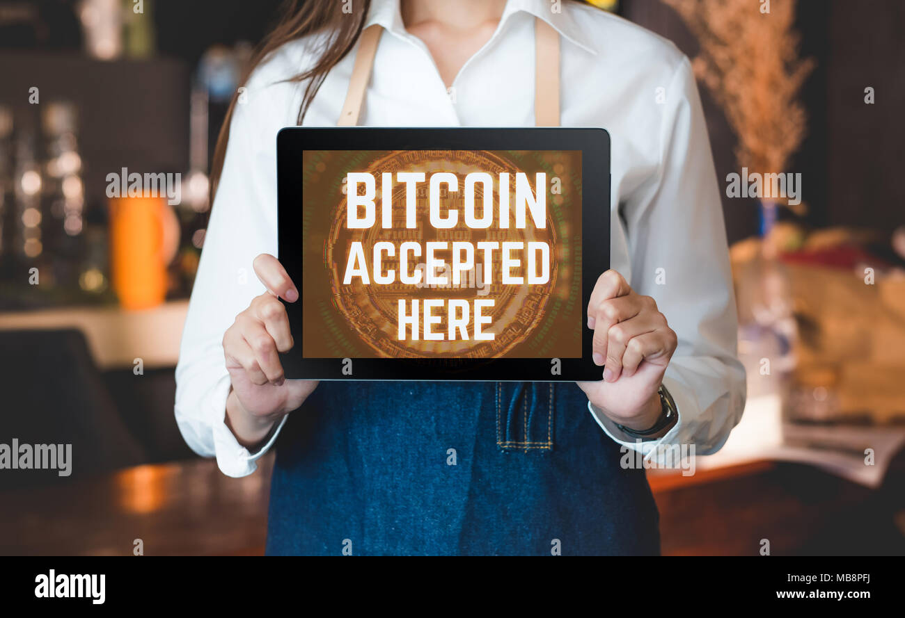 Close up woman barista holding tablet and show bitcoin accepted here on  tablet screen at cafe counter bar,seller coffee shop accept payment by  crypto Stock Photo - Alamy