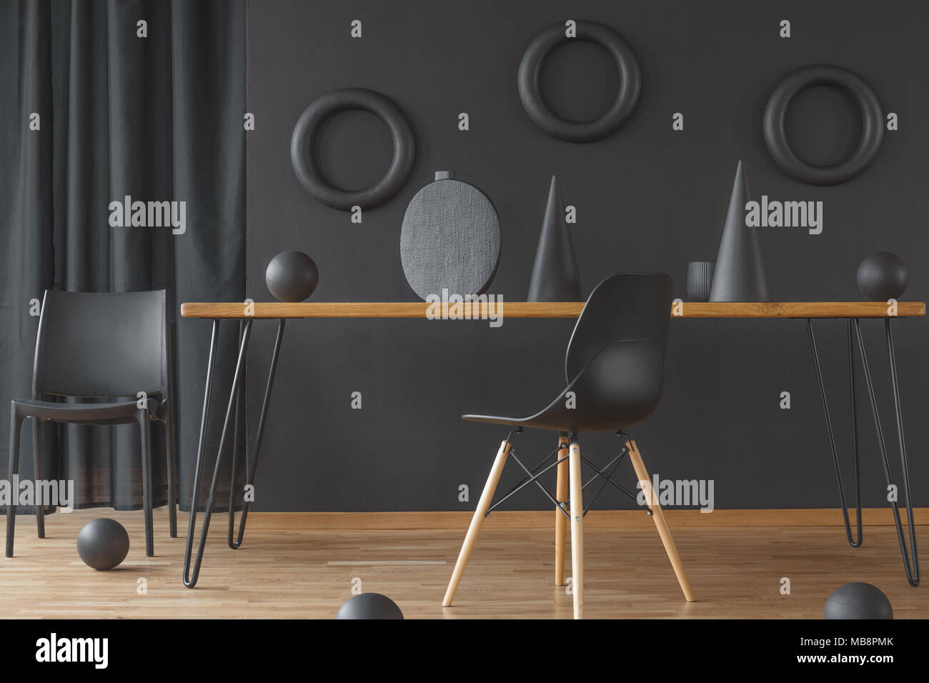 Black and wood dining room interior with hairpin table, two chairs and