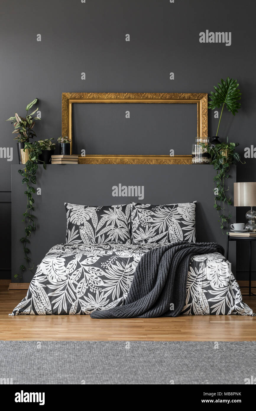 Empty gold mockup frame placed on a wall shelf with books and