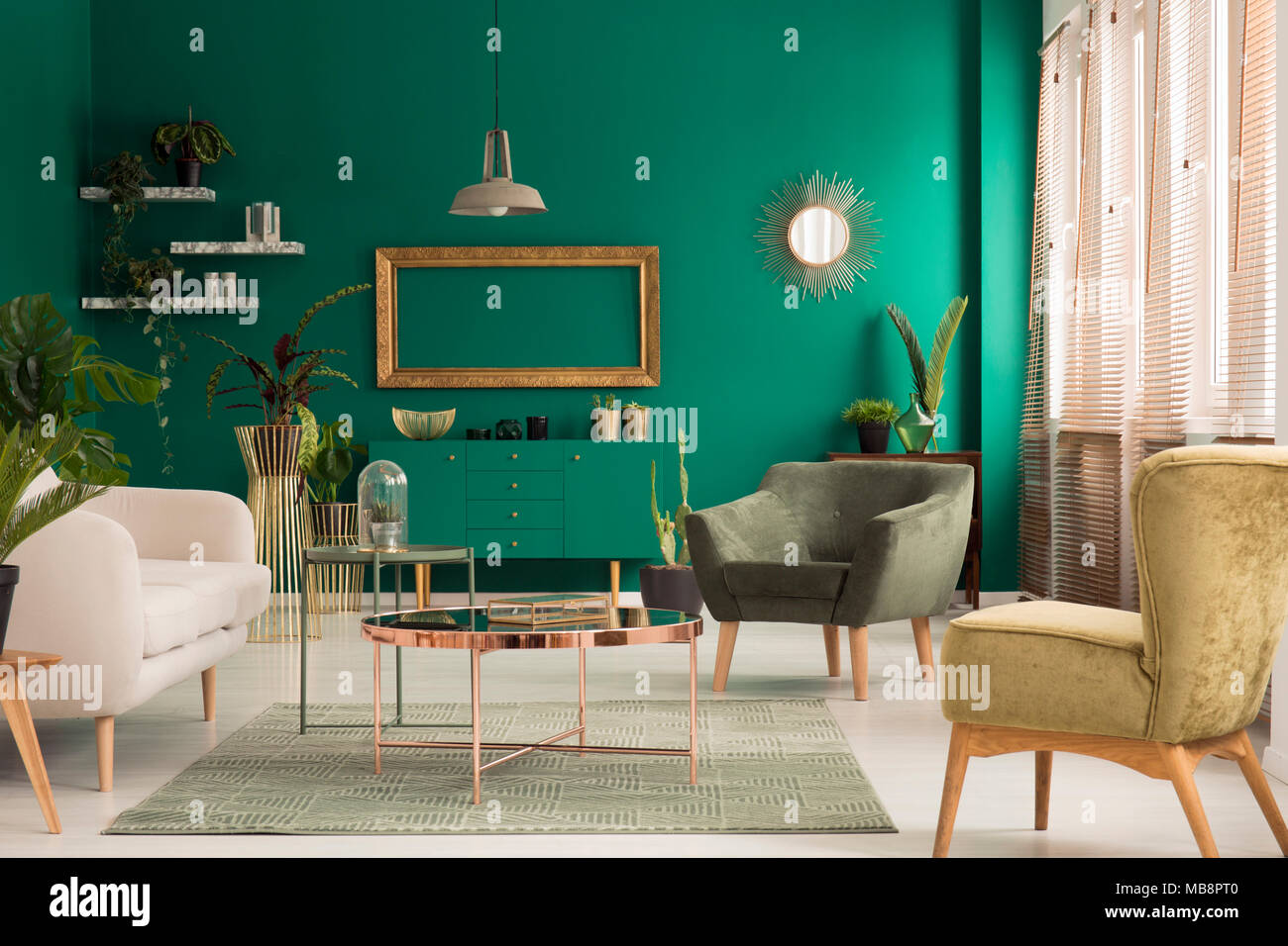 Copper table on rug and gold frame in living room interior with green