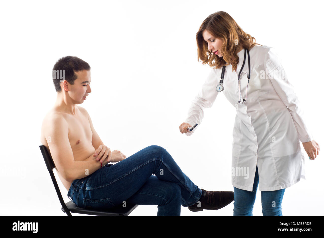 Girl doctor checks a nervous reflex in a patient of East Asian appearance (isolated on white) Stock Photo