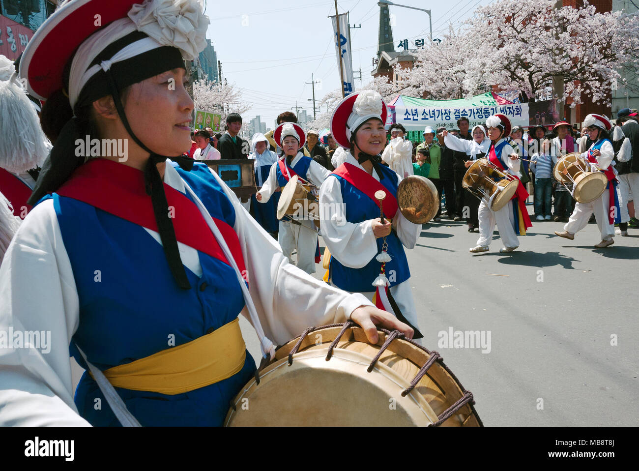 Women perform a traditional dance known as Pungmulnori at a neighborhood festival celebrating the blooming of the cherry blossoms in Spring. Stock Photo